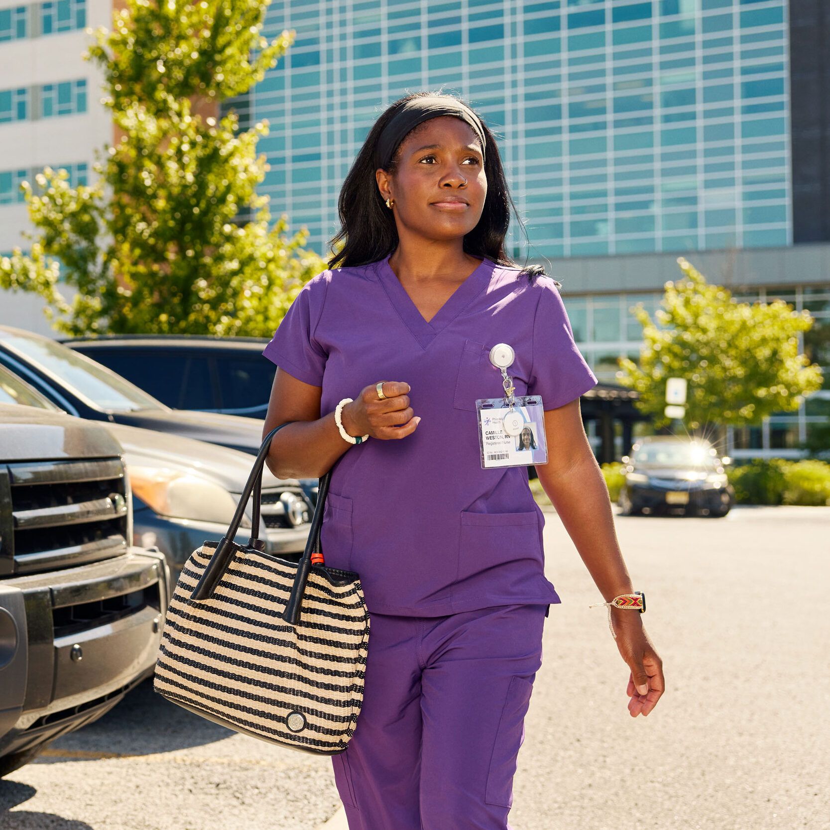nurse in scrubs walking in a parking lot wearing a ROAR Alert Device on her top