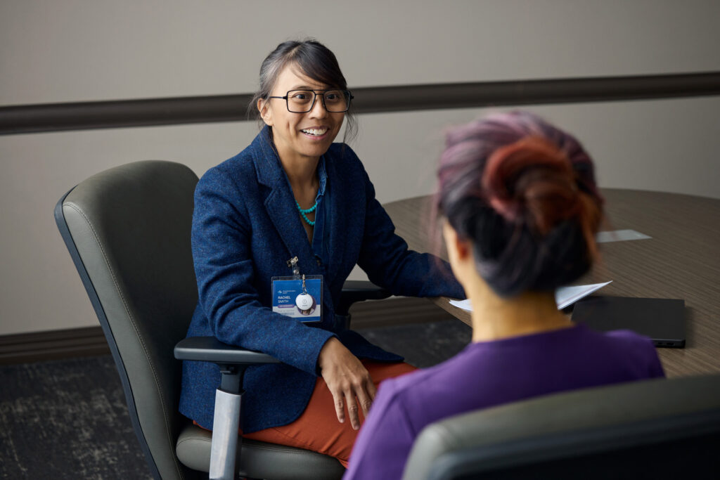 HR professional with ROAR Alert Device on her jacket talking with a nurse in a conference room